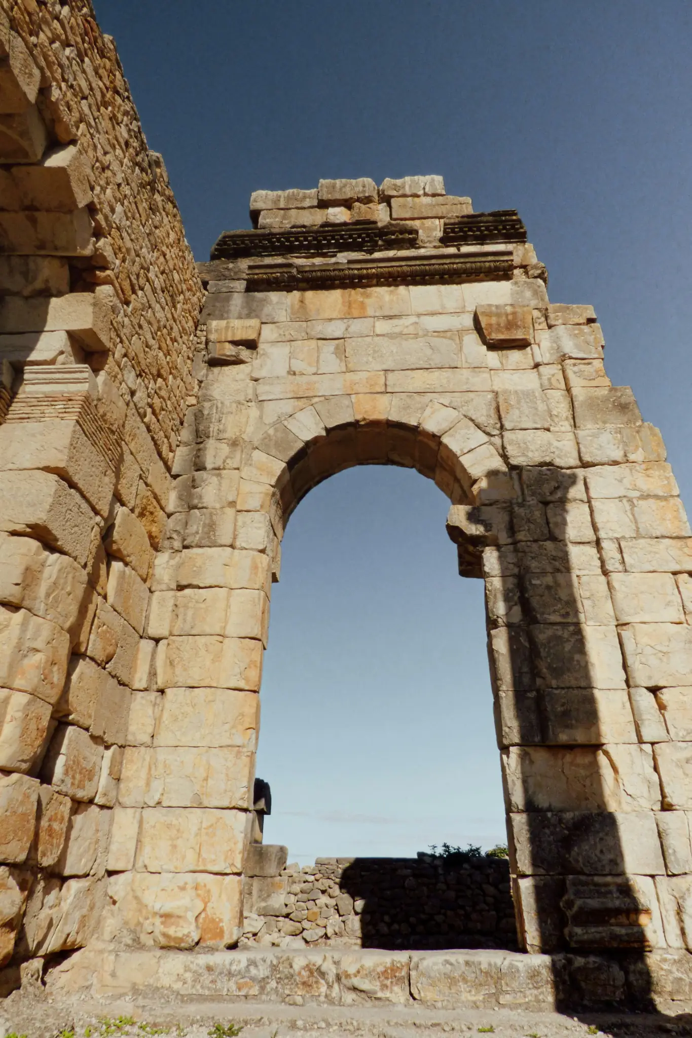 Ancient Roman ruins and archways at Volubilis, a top historical excursion included on day-trip Fes